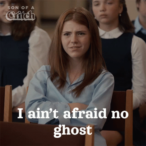A Girl Sitting In A Classroom With The Words I Ain 'T Afraid No Ghost GIF