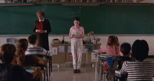 A Girl Stands In Front Of A Blackboard With The Word Dignity On It GIF