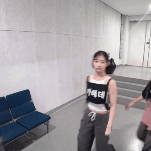 A Girl Wearing A Black Tank Top That Says ' Ae ' On It GIF