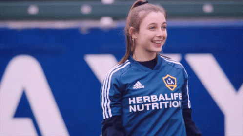 A Girl Wearing A Blue Adidas Herbalife Nutrition Shirt GIF