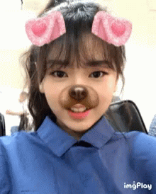 A Girl Wearing A Blue Shirt Has A Fake Dog Nose On Her Face .. GIF