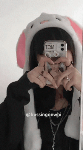 A Girl Wearing A Bunny Hat Takes A Picture Of Herself In A Mirror GIF