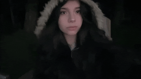 A Girl Wearing A Fur Hooded Jacket Looks At The Camera GIF