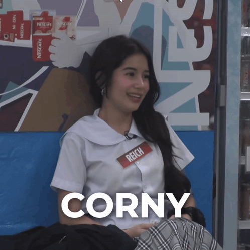 A Girl Wearing A Name Tag That Says Corny GIF