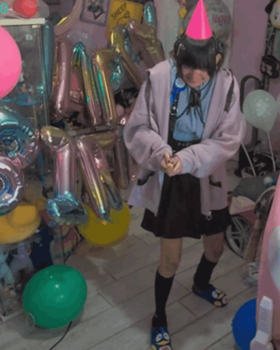A Girl Wearing A Pink Party Hat Stands In A Room Filled With Balloons GIF
