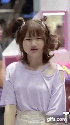 A Girl Wearing A Purple Shirt Is Making A Face . GIF