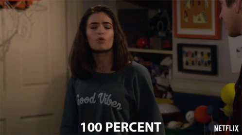 A Girl Wearing A Sweater That Says Good Vibes Blows A Kiss GIF