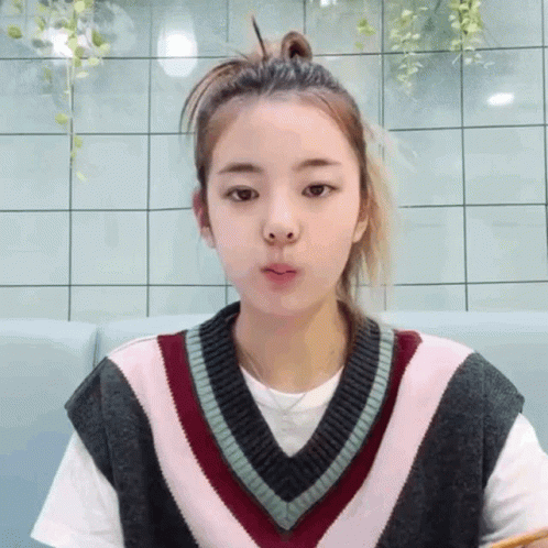 A Girl Wearing A Sweater Vest And A White Shirt GIF