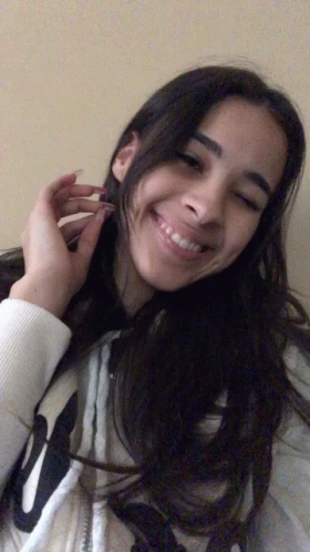 A Girl Wearing A White Sweatshirt With The Letter W On It Smiles For The Camera GIF