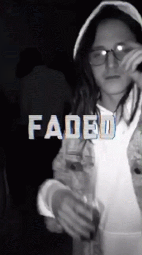 A Girl Wearing Glasses And A Hooded Jacket With Faded Written In White Letters GIF