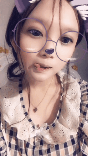 A Girl Wearing Glasses And A Plaid Shirt Has A Purple Nose GIF