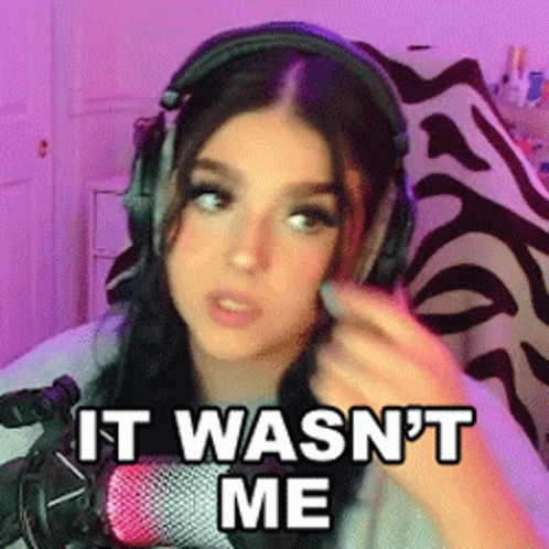 A Girl Wearing Headphones Is Sitting In Front Of A Microphone And Saying It Wasn 'T Me . GIF