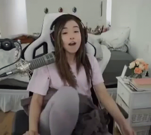 A Girl Wearing Headphones Is Sitting In Front Of A Microphone In A Room . GIF