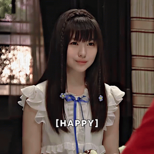 A Girl With A Blue Ribbon In Her Hair Is Smiling With The Words [ Happy ] Next To Her GIF