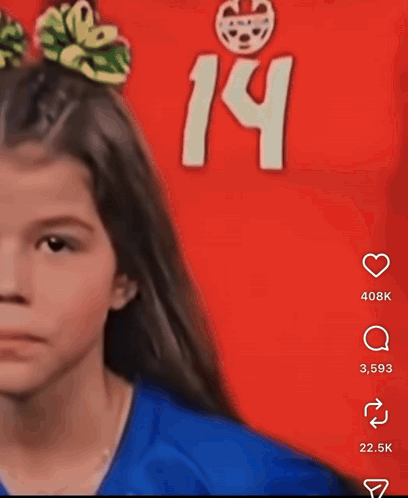 a girl with a bow in her hair stands in front of a red background with the number 14