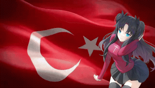 A Girl With A Cross On Her Shirt Stands In Front Of A Flag GIF