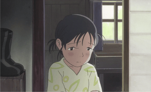 a girl with a sad look on her face stands in a doorway