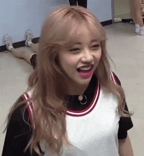 A Girl With Blonde Hair And Pink Lips Is Laying On The Floor . GIF