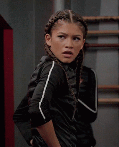 A Girl With Braids In Her Hair Is Wearing A Black Jacket GIF