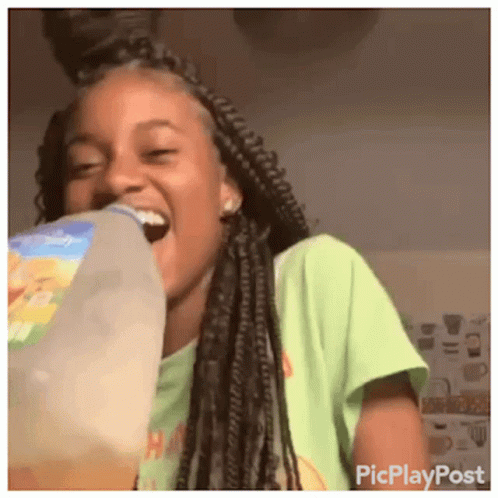 A Girl With Braids Is Drinking From A Bottle Of Milk GIF