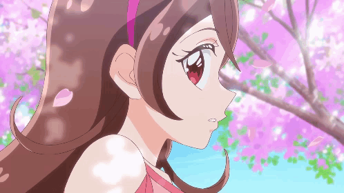 A Girl With Brown Hair And Red Eyes Is Standing In Front Of A Tree With Pink Flowers GIF