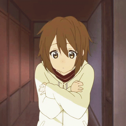 A Girl With Brown Hair Is Standing With Her Arms Crossed In A Hallway GIF