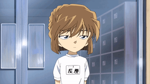 A Girl With Chinese Writing On Her Shirt Is Standing In Front Of A Row Of Lockers GIF