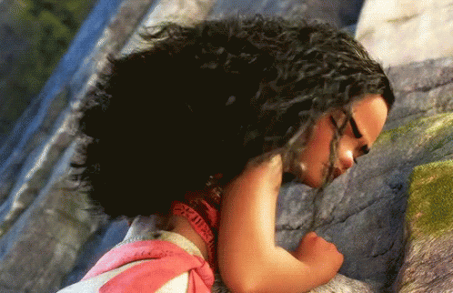 A Girl With Curly Hair Is Laying On A Rock With Her Eyes Closed GIF