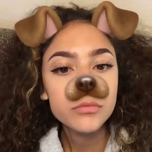 A Girl With Curly Hair Is Wearing A Dog Face Mask . GIF