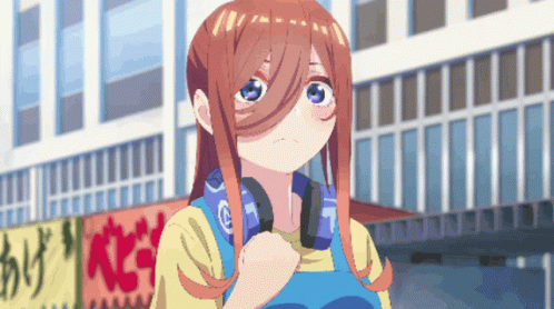 A Girl With Headphones Around Her Neck Is Standing In Front Of A Building GIF