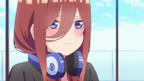 A Girl With Headphones Around Her Neck Looks At The Camera GIF