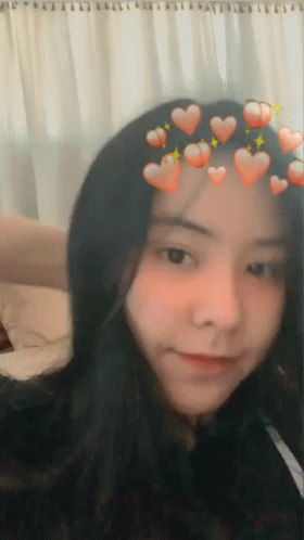 A Girl With Hearts On Her Head Is Smiling GIF