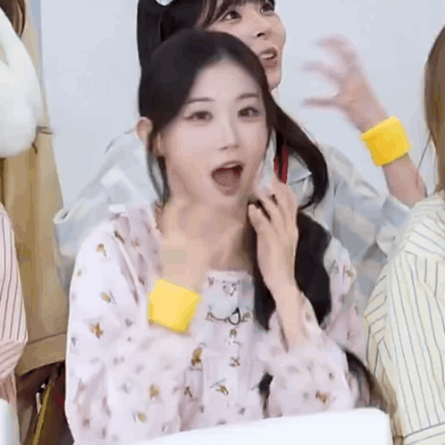 A Girl With Her Mouth Open And A Yellow Wristband Around Her Wrist . GIF