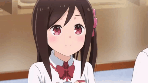 A Girl With Long Brown Hair And A Red Bow Tie Is Looking At The Camera . GIF