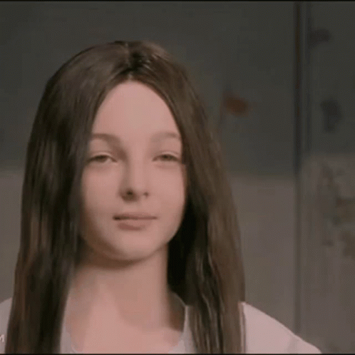 A Girl With Long Dark Hair Is Wearing A Wig GIF