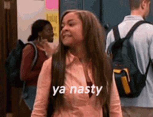 A Girl With Long Hair And A Backpack Is Standing In A Hallway With Other People . GIF