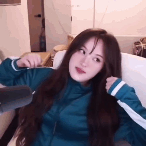 A Girl With Long Hair Is Sitting On A Couch . GIF