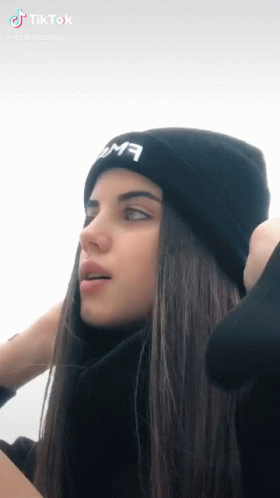 A Girl With Long Hair Wearing A Black Beanie GIF