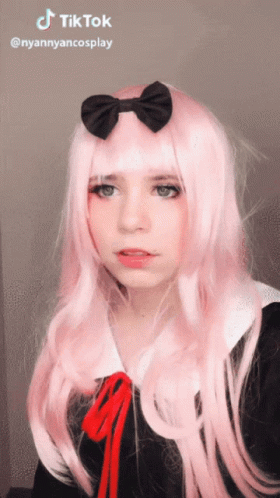 A Girl With Long Pink Hair And A Black Bow On Her Head Has A Tiktok Watermark GIF