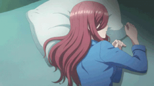 A Girl With Long Red Hair Is Laying On A Bed GIF