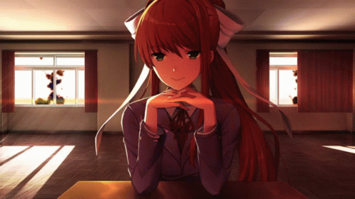 A Girl With Long Red Hair Sits At A Table With Her Hands On Her Chin GIF