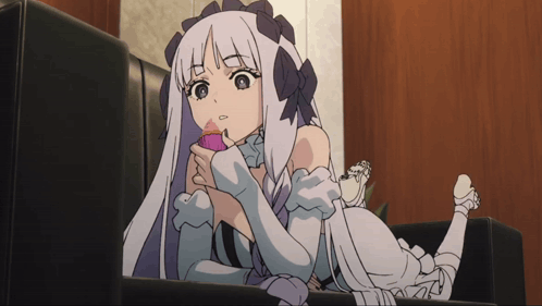 A Girl With Long White Hair Is Laying On A Couch With Her Legs Crossed GIF