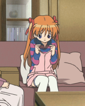 A Girl With Orange Hair Is Sitting On A Couch In A Living Room GIF