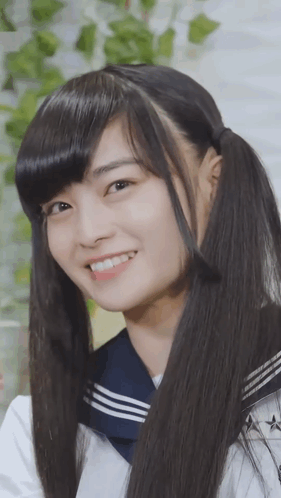 A Girl With Pigtails And A Sailor Uniform Smiles For The Camera GIF