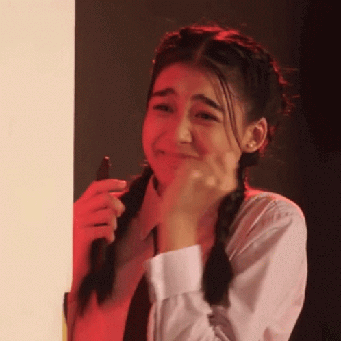 A Girl With Pigtails Is Crying While Holding A Cell Phone In Her Hand . GIF