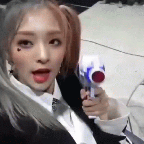 A Girl With Pigtails Is Holding A Toy Gun In Her Hand . GIF