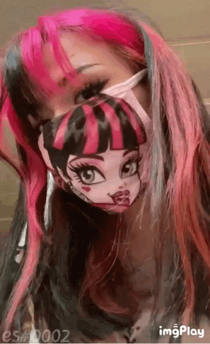 A Girl With Pink And Black Hair Is Wearing A Monster High Mask . GIF