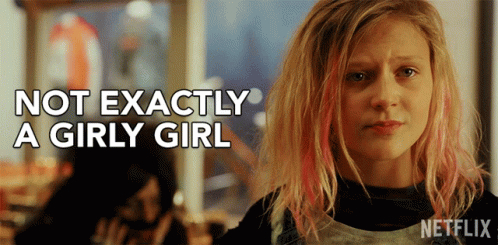 A Girl With Pink Hair And The Words Not Exactly A Girly Girl Behind Her GIF
