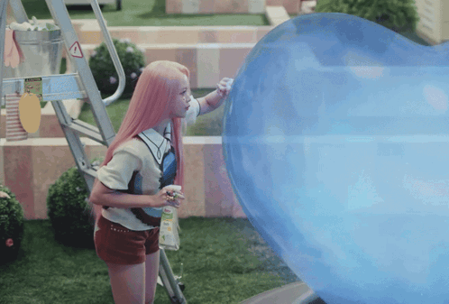A Girl With Pink Hair Is Standing Next To A Large Blue Balloon GIF
