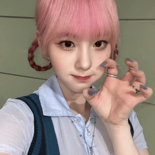 A Girl With Pink Hair Is Wearing A Blue Necklace GIF